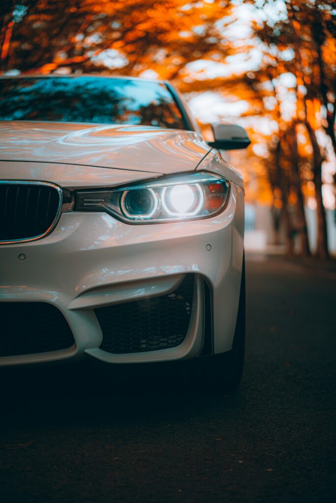 Stylish White Car in Autumn Background with Modern Headlights Wallpaper
