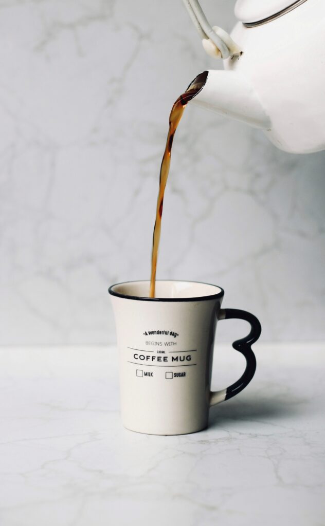 White Coffee Mug Filled with Coffee Against Marble Wallpaper