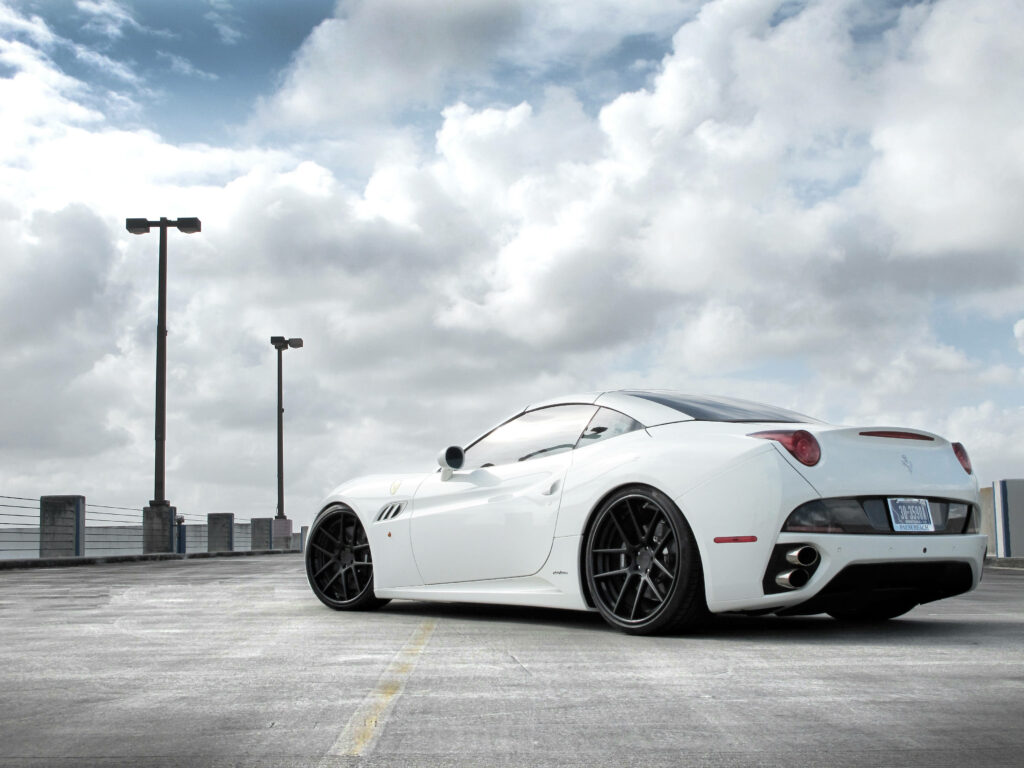 Elegance in Motion: A Majestic White Ferrari Resplendent against a Cloudy Sky Wallpaper