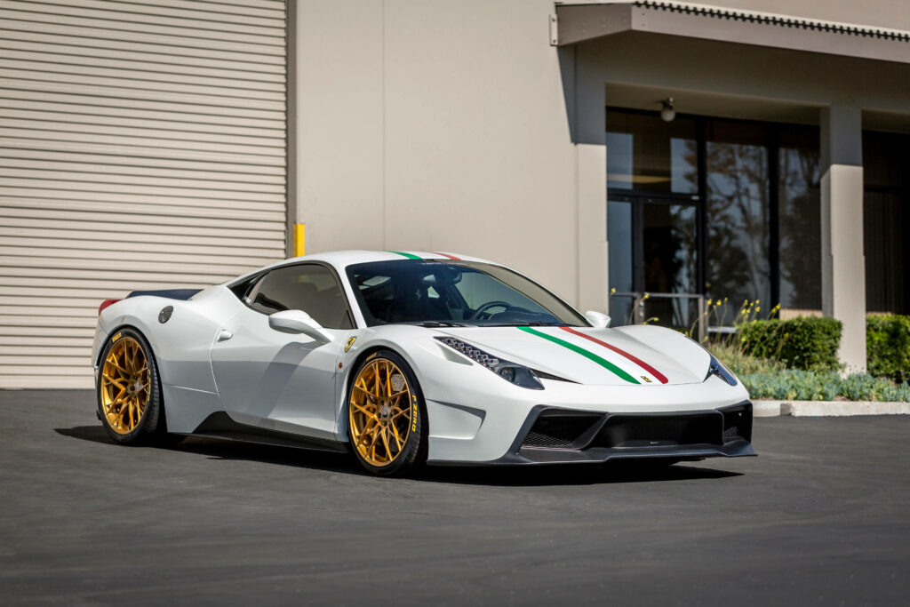 Exquisite White Ferrari Showcase: Vibrant Yellow Rim Adorns Sleek Sports Car Against Garage Backdrop Wallpaper