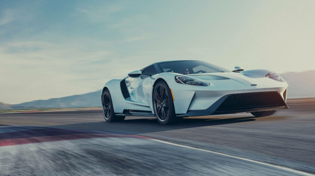 White Ford GT sports car racing on track showcasing sleek aerodynamic design and power Wallpaper