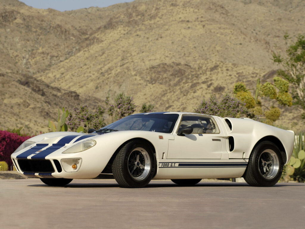 White Ford GT with blue racing stripes parked by desert mountains showcasing classic design Wallpaper