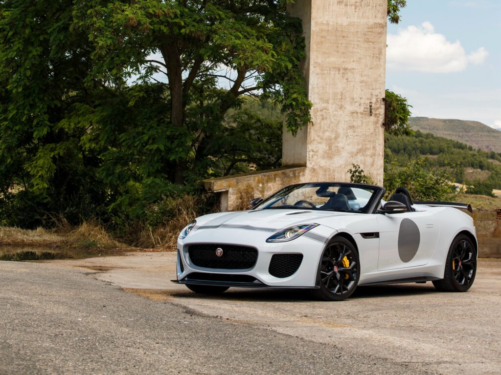 Sleek White Jaguar F-Type Project 7 in Rustic Outdoor Setting Wallpaper