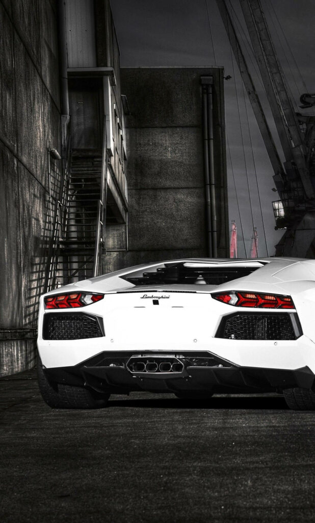 White Lamborghini sports car with sleek design and glowing rear lights in urban background wallpaper