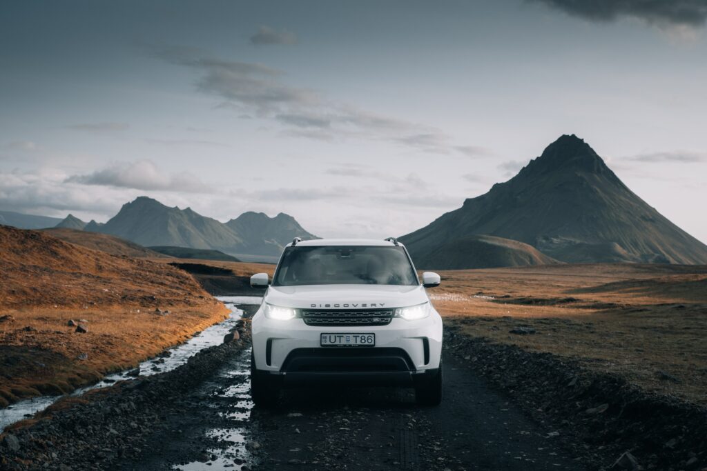 White Land Rover Discovery SUV in Dramatic Mountainous Landscape Wallpaper