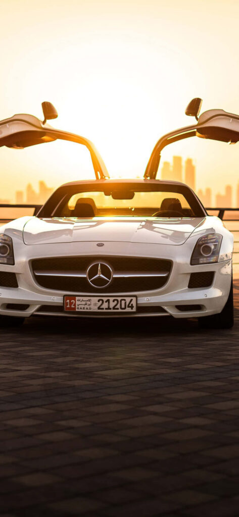 White Mercedes AMG with gullwing doors open at glowing sunset luxury car wallpaper background
