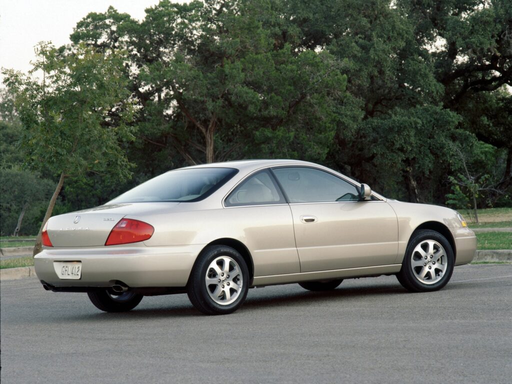 White Metallic Acura CL Parked Amidst Lush Green Trees Wallpaper