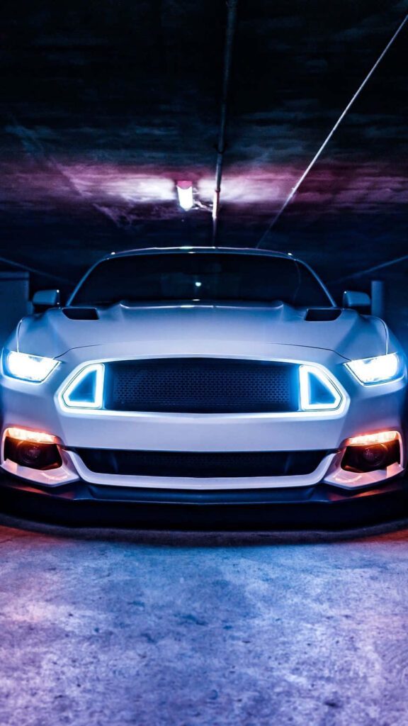Front view of white Mustang with blue orange LED headlights in dim garage dynamic wallpaper
