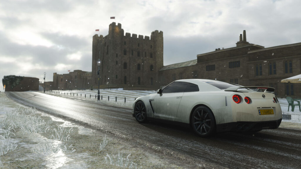 White Nissan GTR racing on icy road past historic castle Forza 4 dynamic wallpaper background