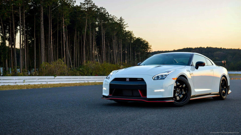 White Nissan GT-R on open racetrack at sunset showcasing sleek design and high performance Wallpaper