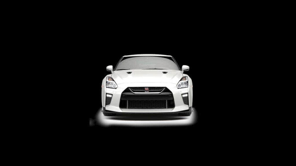 Front view of white Nissan R35 GTR with aggressive design and iconic grille on black background Wallpaper