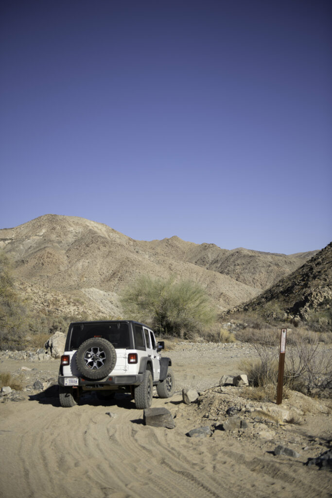 White SUV on Sandy Trail: Rugged Canyon Adventure Wallpaper