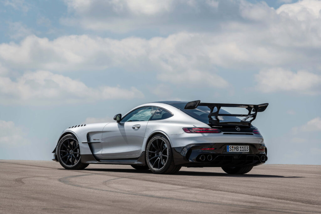 White silver Mercedes GTS rear view showcasing sporty spoiler sleek design aggressive stance sky background Wallpaper