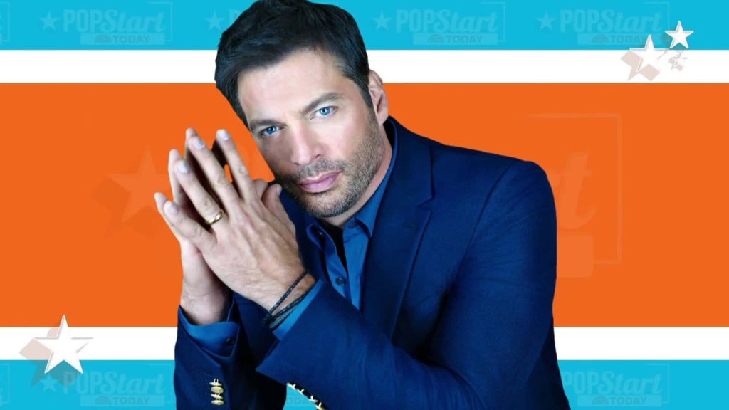 William Levy in navy suit posing confidently against vibrant orange blue POPStart studio background Wallpaper