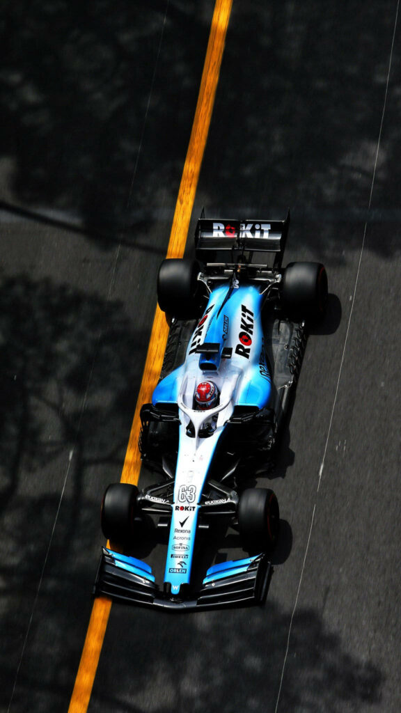 Williams Formula 1 car racing on sunlit road with bold yellow line and dynamic shadows wallpaper