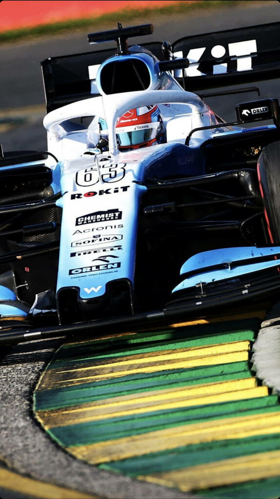 Williams Sports Car 63 racing fast on track with blue and white livery dynamic wallpaper background