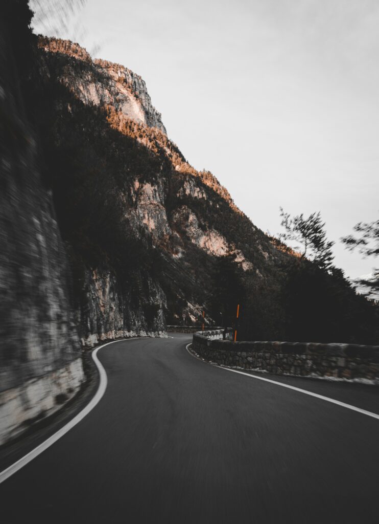 Winding mountain road along rugged cliffs in earthy tones with dramatic natural lighting wallpaper
