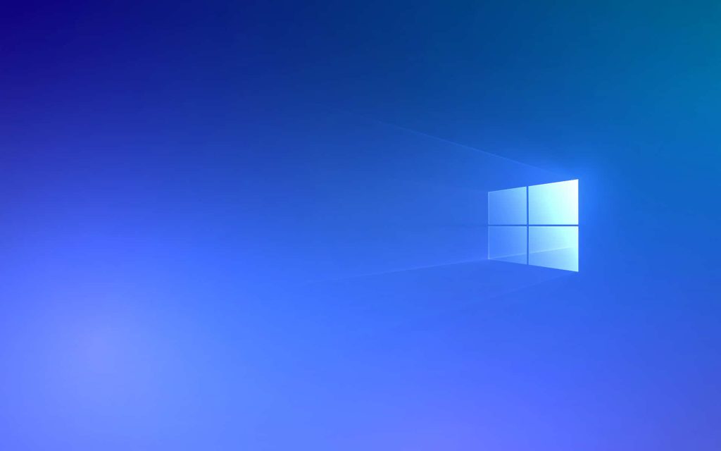 Windows 10 Hero wallpaper glowing light beams Windows logo on deep blue hazy background