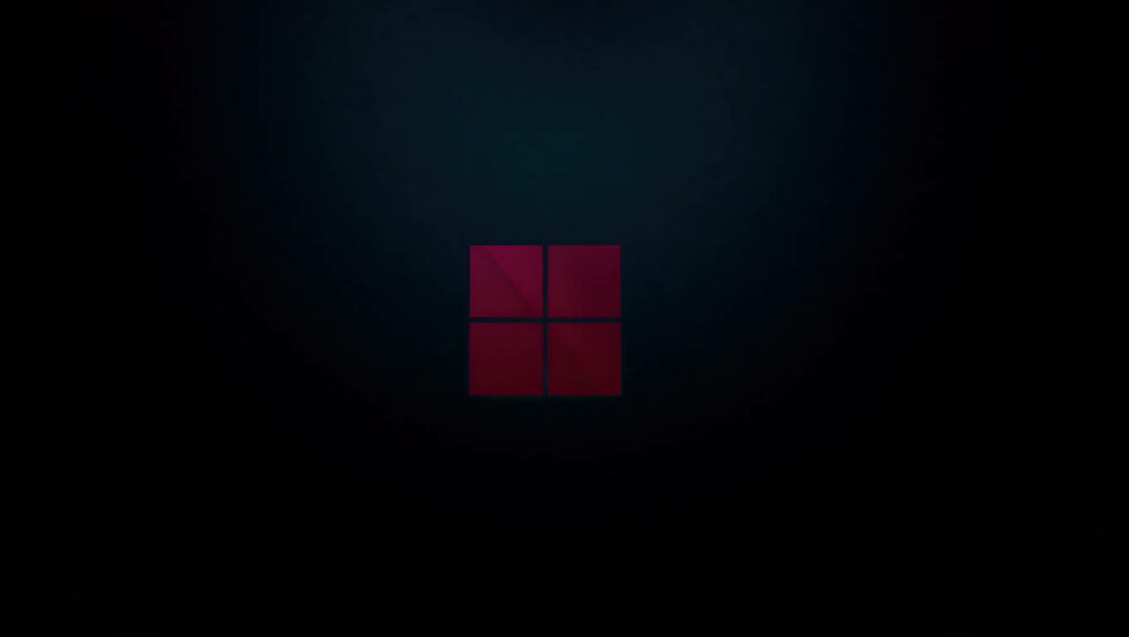 Dazzling Windows 11 Emblem Illuminating a Mysterious Laptop Environment Wallpaper