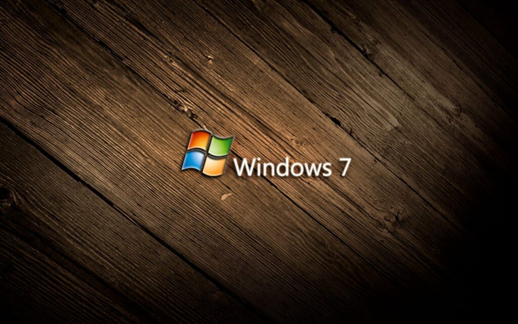 Windows 7 wallpaper with colorful Microsoft logo on rustic dark wooden textured background.