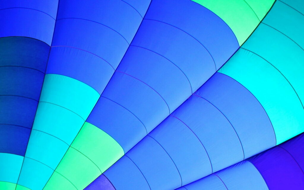 Close-up of vibrant blue cyan and lime green geometric hot air balloon fabric panels wallpaper