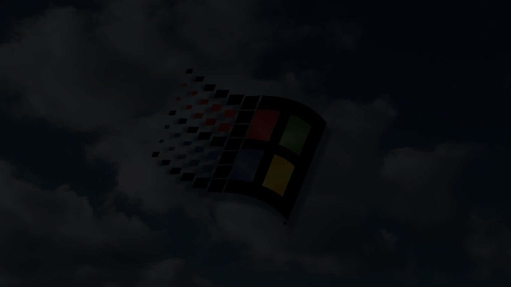Dark moody Windows 98 wallpaper with iconic flag logo and shadowed cloud background vintage style