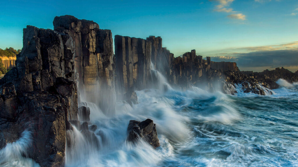 Windows Lock Screen: Majestic Waves Collide with Towering Mountain Wallpaper
