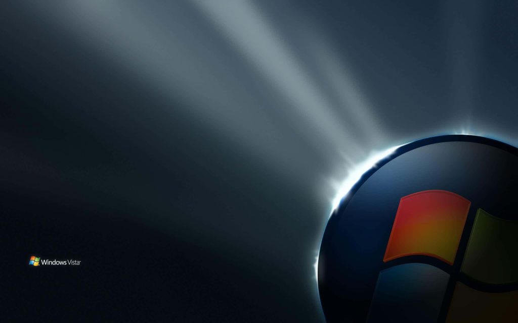 Windows Vista wallpaper with glowing orb logo and radiant light beams on dark background