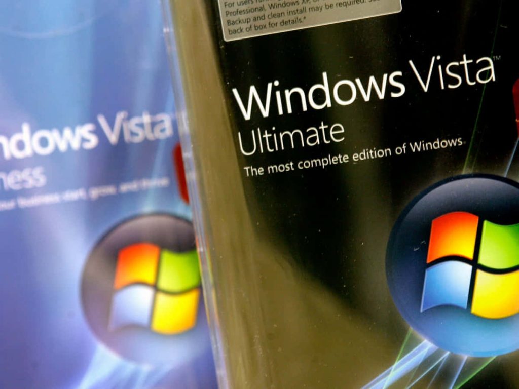 Close-up of Windows Vista Ultimate retail box with colorful orb logo and blurred Business box background Wallpaper
