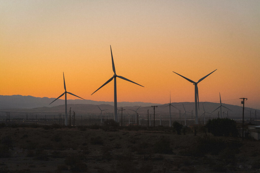 Sunset Serenade: Majestic Windmills Paint the Evening Sky in this Breathtaking Landscape Screensaver Wallpaper
