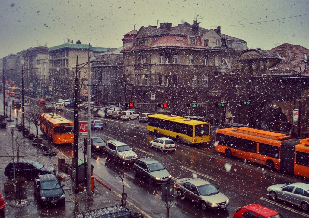 Vibrant Urban Winter Wallpaper: Snowy City Street with Buses