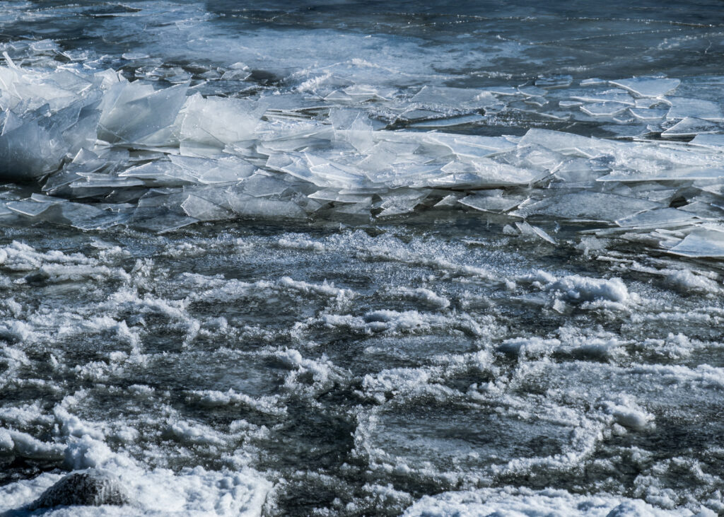 Winter river scene with jagged ice fragments and textured relief in cold blue gray tones Wallpaper