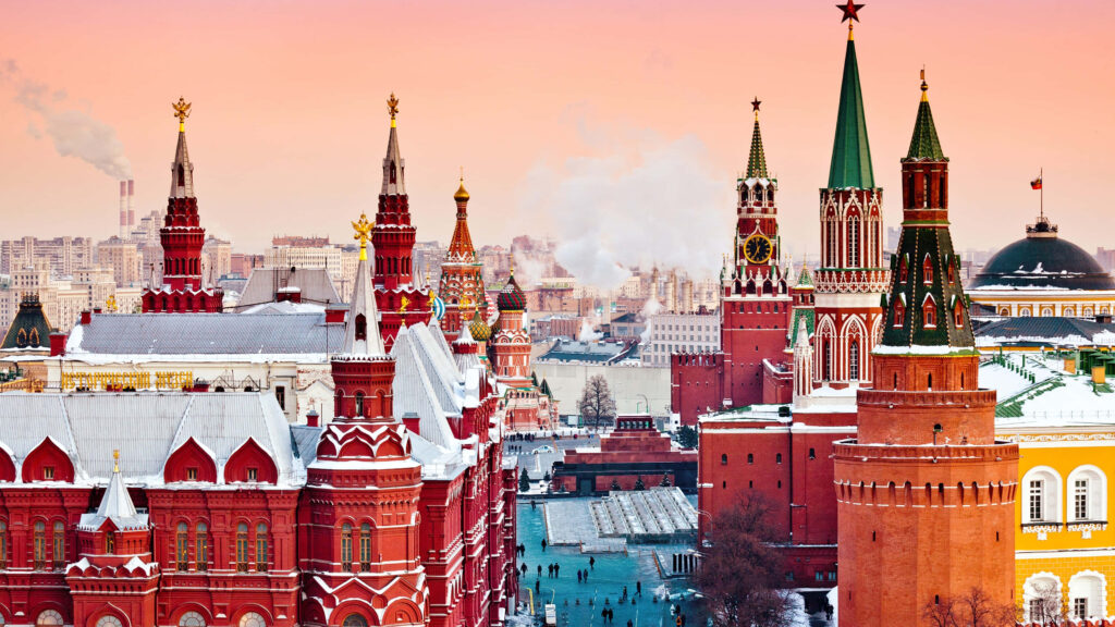 Snow-covered Red Square and Kremlin towers in Moscow under a pink winter sky wallpaper background