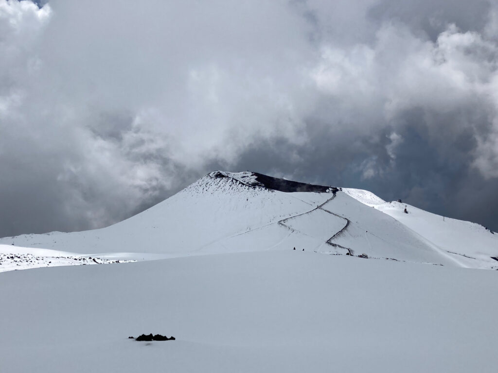 Snow-covered volcano and mountain with dramatic cloudy sky winter landscape wallpaper background