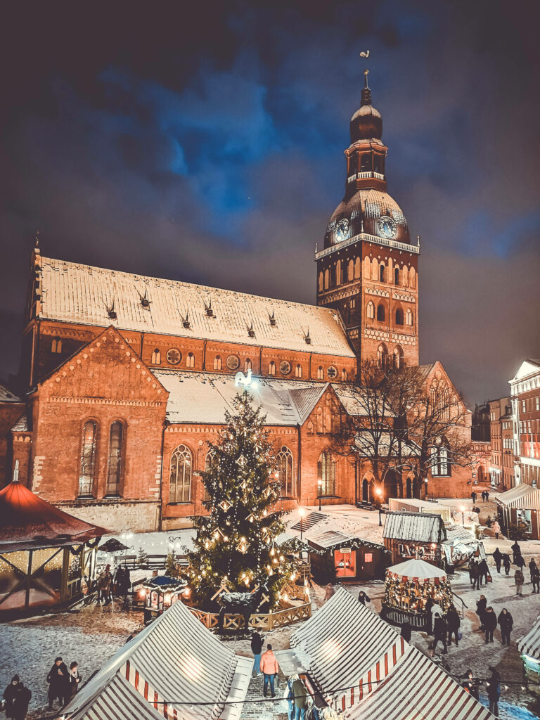 Enchanting Winter Scene at Riga's St. Peter Church with Christmas Tree Wallpaper