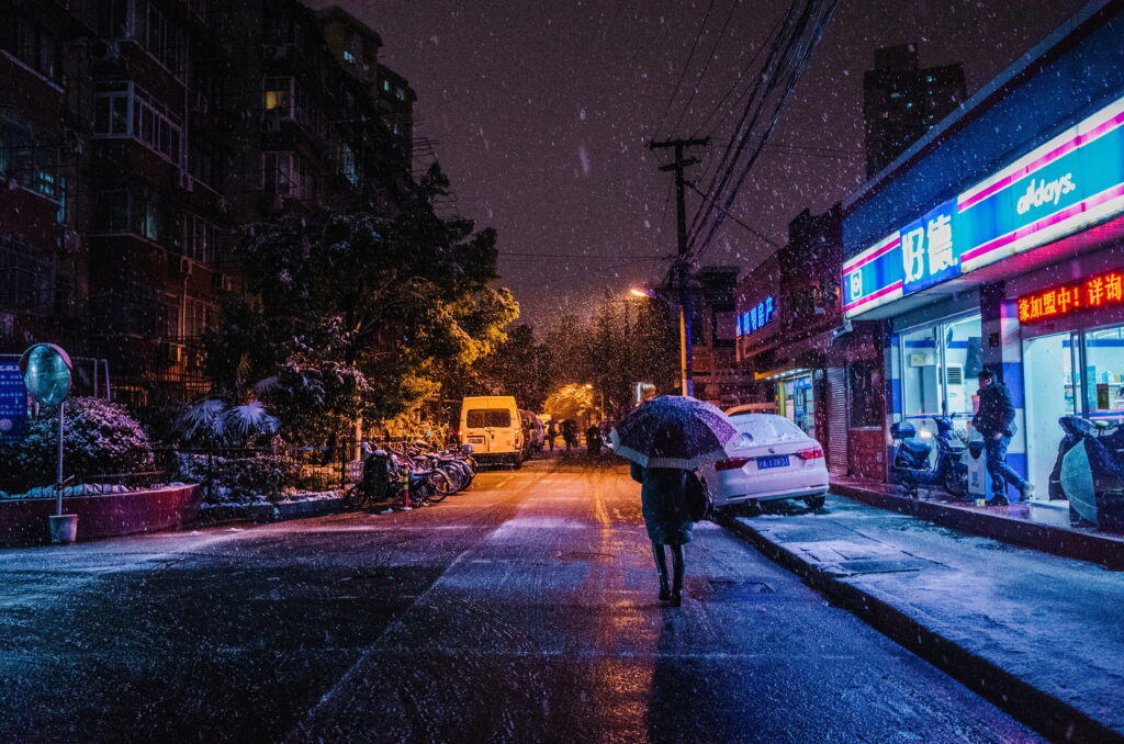 Winter Wanderers: Mesmerizing Snowy City Stroll under Moonlight Wallpaper