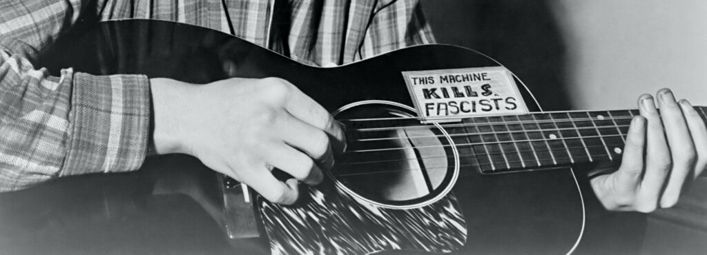 Woody Guthrie's Guitar: Iconic 'This Machine Kills Fascists' Wallpaper