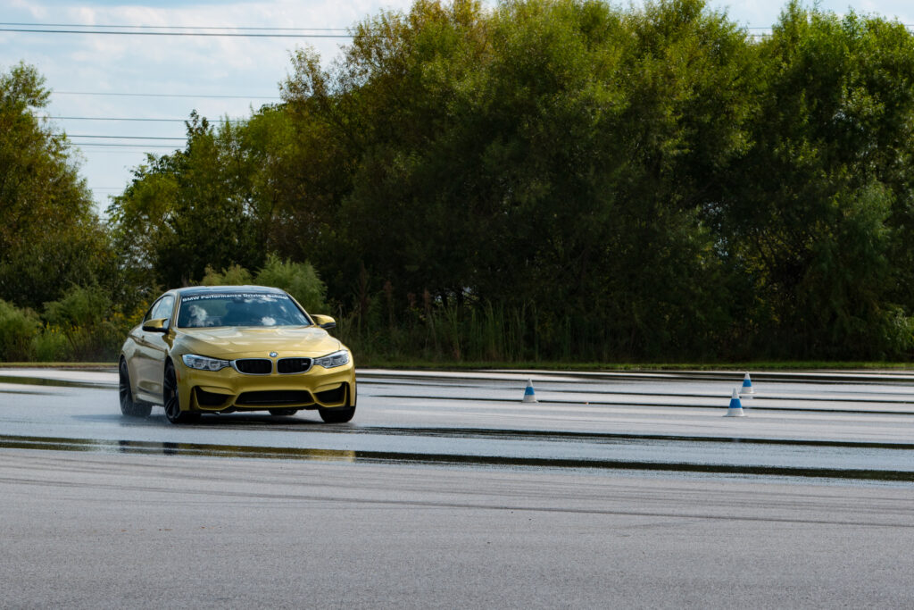 Yellow BMW on Wet Road: Performance & Agility in Lush Greenery Wallpaper