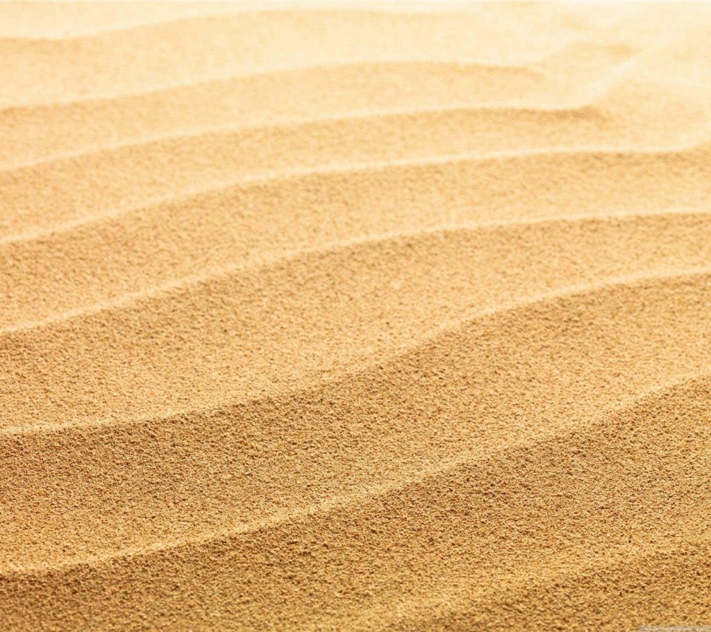 High-resolution yellow beach sand wallpaper with wavy ripple patterns on desert dunes background