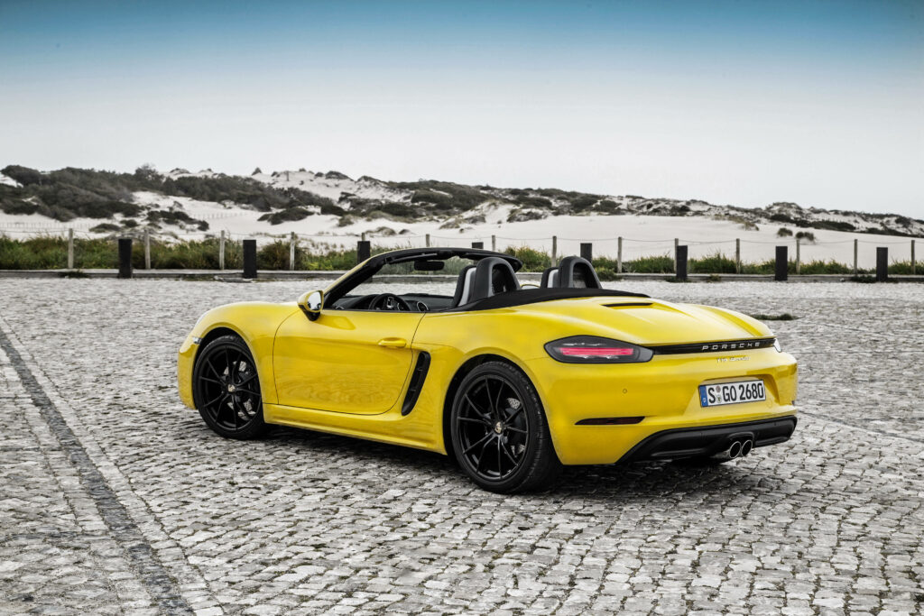 Sunny Drive: Enjoying the Scenic View with a Yellow Porsche Boxster Convertible Wallpaper