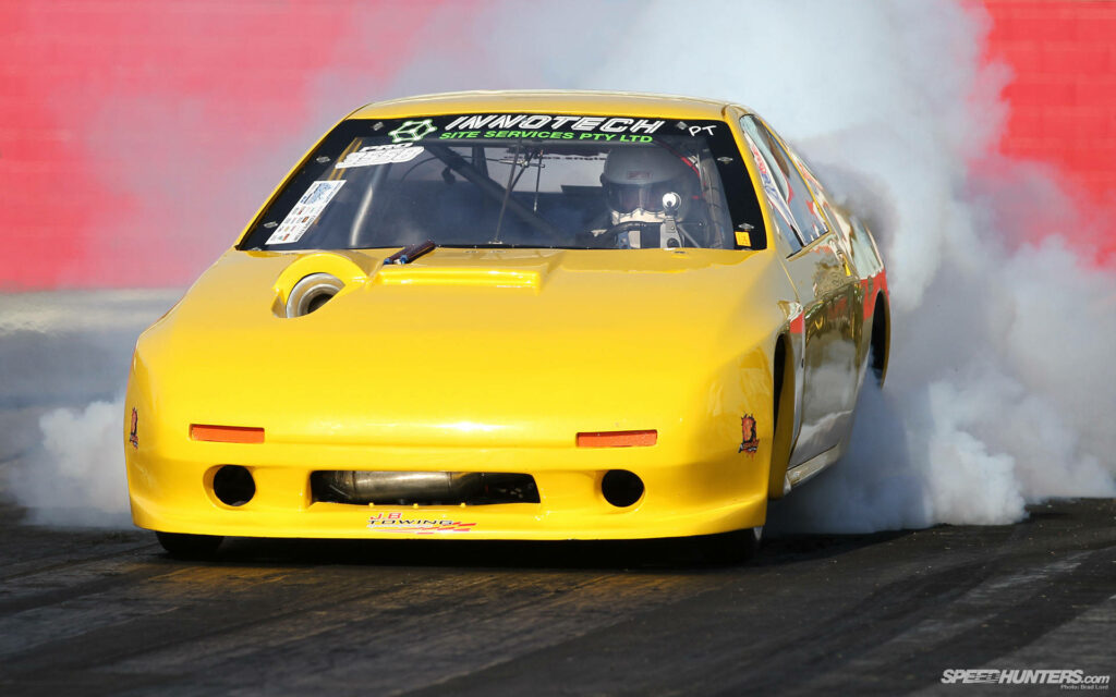Blazing Trails: The Mazda Rx-7 Unleashing Power on the Track, Amidst a Vibrant Yellow Aura and Billowing Burnout Smoke Wallpaper