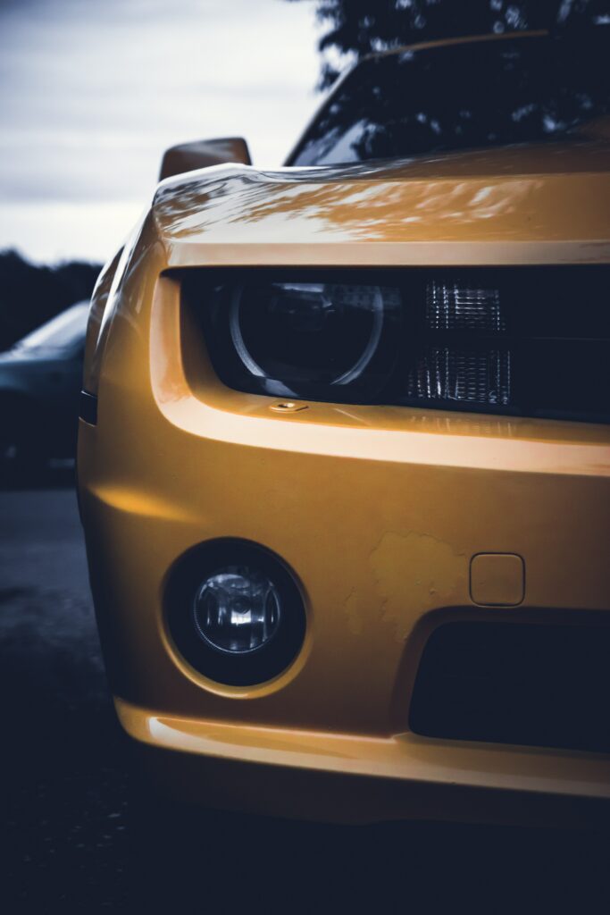 Striking Yellow Car Wallpaper with Detailed Headlights & Moody Background