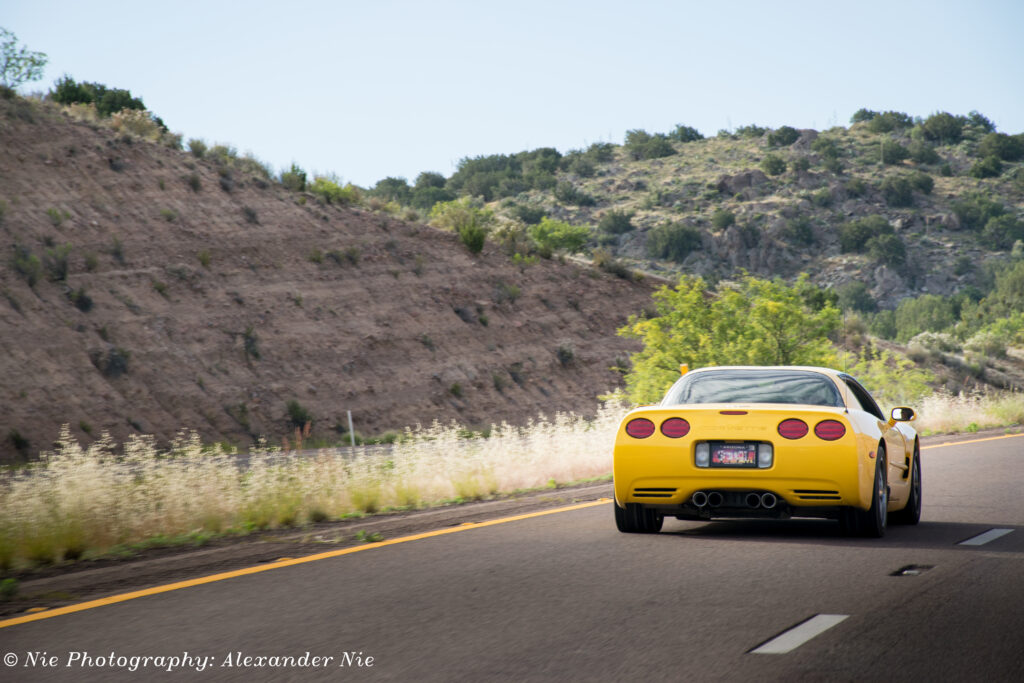 Yellow Chevrolet Corvette C5 on Open Road: Freedom & Adventure Wallpaper