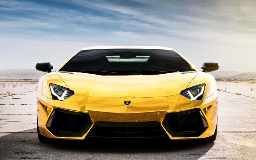Yellow gold Lamborghini with sleek angular design parked on sunlit open paved surface wallpaper