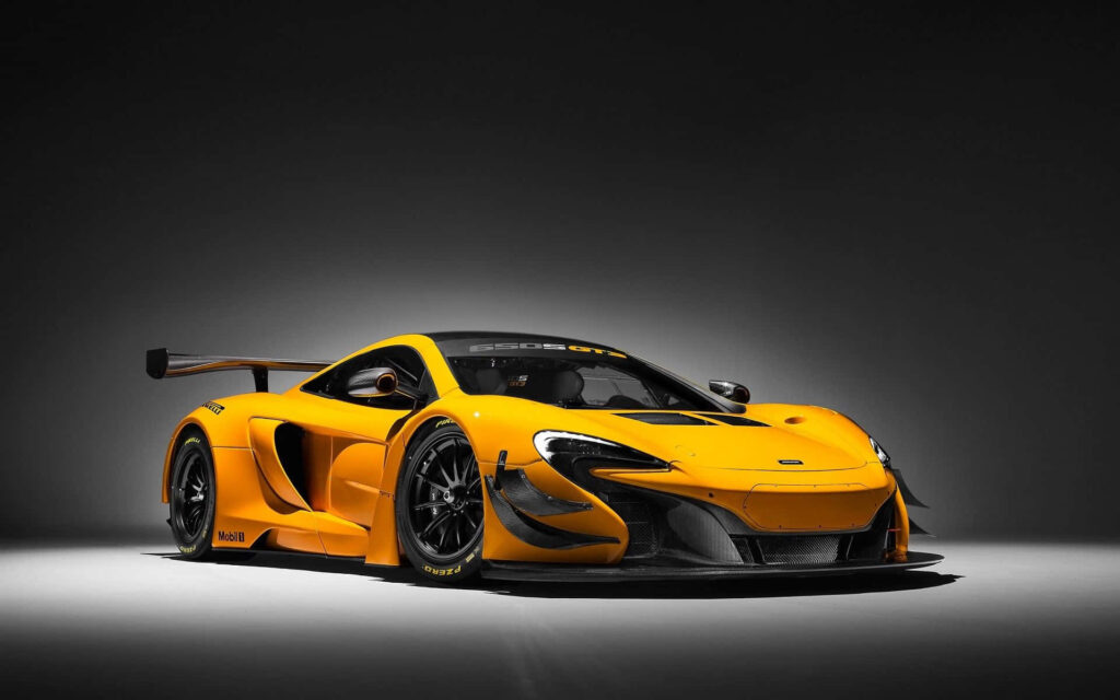 Yellow McLaren sports car with sleek aerodynamic design and bold racing features under lights Wallpaper