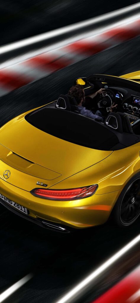 Yellow Mercedes AMG convertible speeding on racetrack showcasing luxury design and power Wallpaper