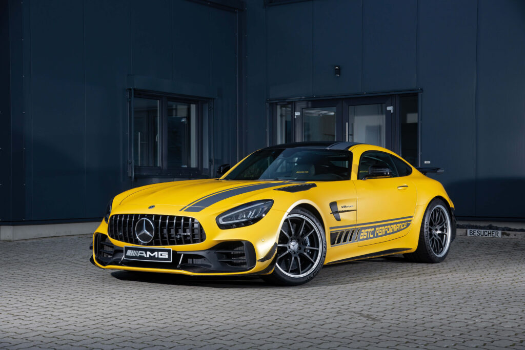 Yellow Mercedes AMG GT R parked by modern building showcasing sporty aggressive design wallpaper