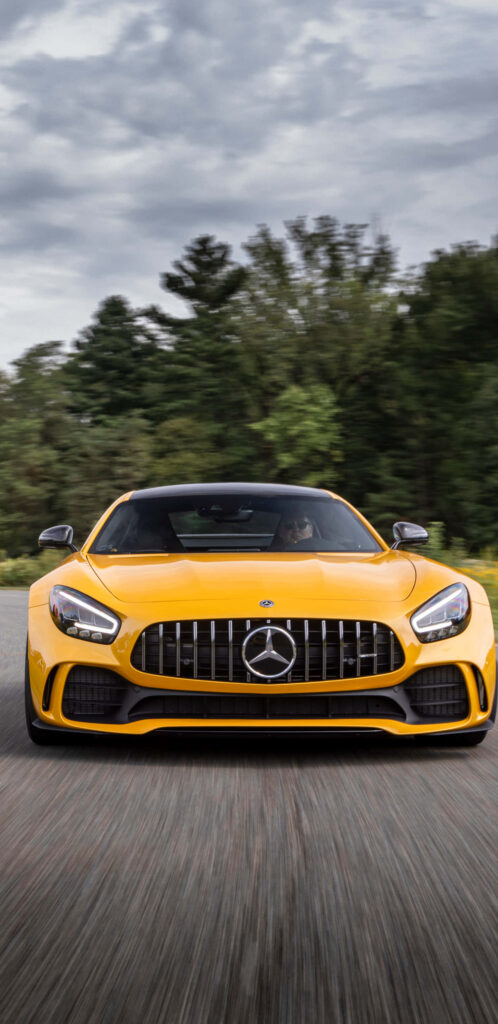 Yellow Mercedes-Benz AMG GT-R front view with bold grille sporty design outdoor wallpaper background