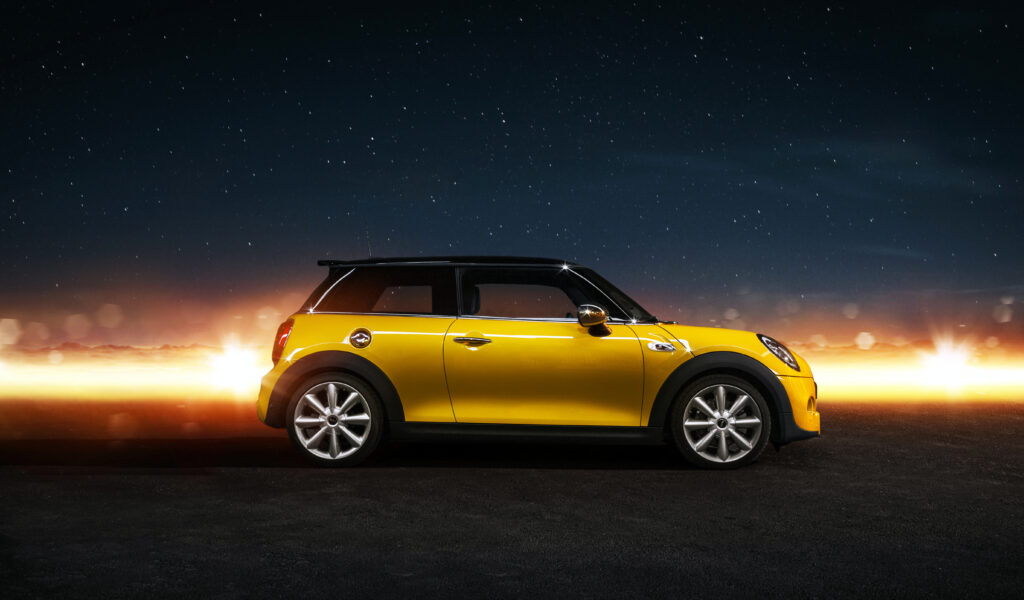 Yellow Mini Cooper S Against Starry Sky: Sleek Design Wallpaper