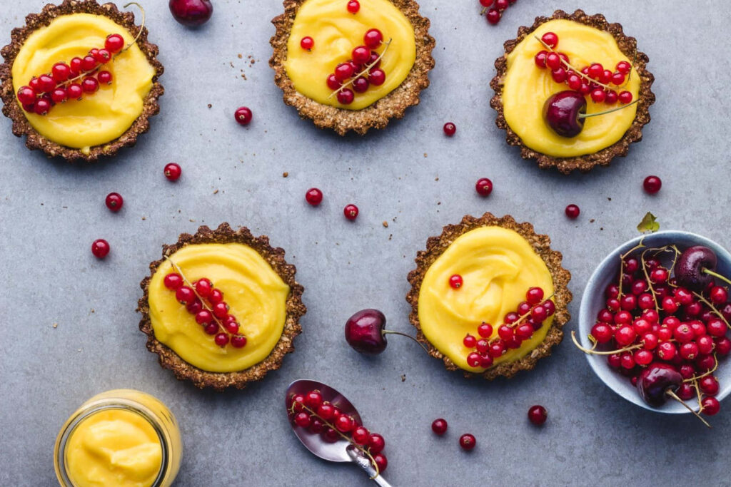 Deliciously Vibrant Mini Tart Delights Garnished with Zesty Red Berries Wallpaper